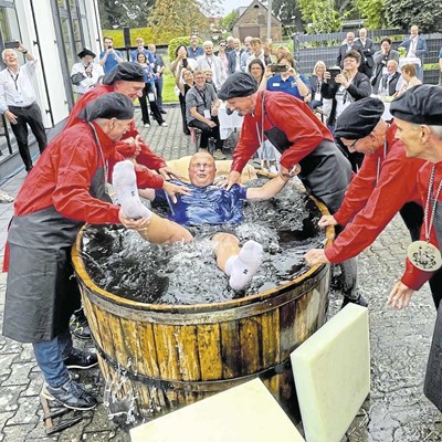Sieben Gäutschlinge wurden bei der Feier zum 90-jährigen Bestehen des Bünder Unternehmens Mail Druck & Medien gegautscht, also nach ihrer bestandenen Abschlussprüfung in einer traditionellen Freisprechungszeremonie in einer Bütte (einem Holzfass) untergetaucht. Die Packer (in Rot) spielen bei der Zeremonie eine wichtige Rolle.